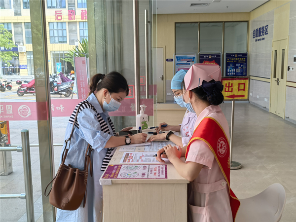 2.市妇幼保健院工作人员指引群众填写流调表和扫粤康码、行程码,进行核酸采样_副本.jpg